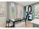 Breakfast nook with black table, white cushioned bench, and patterned curtains at 405 Brooch Way, Stockbridge, GA 30281