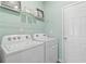 Bright laundry room with Whirlpool washer and dryer and light green walls at 405 Brooch Way, Stockbridge, GA 30281