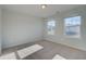 A neutral-toned bedroom featuring two large windows and plush carpeting at 108 Dalston Cv, Stockbridge, GA 30281