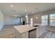 Island seating area looks over sink and storage, towards adjacent living area with fireplace and exterior views at 108 Dalston Cv, Stockbridge, GA 30281