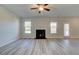 Living room with tile fireplace, wood-look floors, ceiling fan and neutral paint at 108 Dalston Cv, Stockbridge, GA 30281