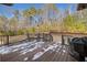 Deck with wooded views and a grill, partially covered with snow at 121 Harmony Oaks Trl, Canton, GA 30115