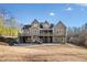 Two-story house with large deck, screened porch and partial view of wooded lot at 121 Harmony Oaks Trl, Canton, GA 30115