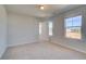 Bright bedroom with carpet flooring and two windows at 205 Chiswick Loop, Stockbridge, GA 30281