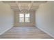 Formal dining room with coffered ceiling, chandelier, and vinyl flooring at 205 Chiswick Loop, Stockbridge, GA 30281