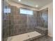 Large walk-in shower with gray tile and built-in seat at 205 Chiswick Loop, Stockbridge, GA 30281