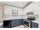 Galley style kitchen with white cabinets and stainless steel appliances at 1482 Kings Ridge Dr, Norcross, GA 30093