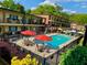 Community pool and apartment building with patio tables and umbrellas at 1705 Monroe Ne Dr # B05, Atlanta, GA 30324