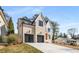 Two-story house featuring a light brick exterior, three-car garage, and a manicured lawn at 2675 S Bamby Ne Ln, Brookhaven, GA 30319