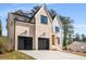 Brick and board and batten two story home with a three-car garage and landscaping at 2675 S Bamby Ne Ln, Brookhaven, GA 30319