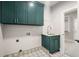 Functional laundry room with green cabinets and patterned tile floor at 2675 S Bamby Ne Ln, Brookhaven, GA 30319