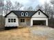 Charming new construction home featuring board and batten siding, black trim, a two-car garage, and a welcoming front porch at 319 Evie Ln, Canton, GA 30115