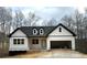 New construction home with board and batten siding, black trim, a two-car garage, and a welcoming front porch at 319 Evie Ln, Canton, GA 30115