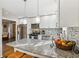 Granite kitchen island with seating, stainless steel appliances, and white cabinets at 409 Katherine Ln, Woodstock, GA 30189