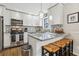 Modern kitchen featuring white cabinets, granite countertops, and stainless steel appliances at 409 Katherine Ln, Woodstock, GA 30189