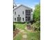 Backyard with a stone patio, chairs, landscaping, and a screened in porch on the second story of a two story home at 9032 Selborne Ln, Chattahoochee Hills, GA 30268