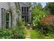 A serene backyard oasis with a stone path, lush greenery, and a charming screened-in porch at 9032 Selborne Ln, Chattahoochee Hills, GA 30268