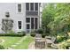 Stone patio with wicker furniture and lush landscaping at 9032 Selborne Ln, Chattahoochee Hills, GA 30268