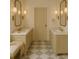 Elegant bathroom featuring dual vanities, marble countertops, decorative mirrors, and neutral tiling at 9032 Selborne Ln, Chattahoochee Hills, GA 30268