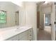 Well-lit bathroom with a vanity and a view into the adjacent room with tile flooring and natural light at 9032 Selborne Ln, Chattahoochee Hills, GA 30268