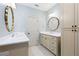 Bright bathroom features dual vanities, white countertops, storage cabinetry, and decorative mirrors at 9032 Selborne Ln, Chattahoochee Hills, GA 30268