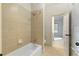 Bathroom features a tiled shower and tub combo, with neutral-toned tile and classic fixtures, and tiled floor at 9032 Selborne Ln, Chattahoochee Hills, GA 30268