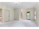 Large bedroom features neutral tones, carpeted floors, multiple windows, and access to a balcony at 9032 Selborne Ln, Chattahoochee Hills, GA 30268