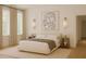 Inviting bedroom with neutral tones, modern artwork, sconces, and ample natural light at 9032 Selborne Ln, Chattahoochee Hills, GA 30268