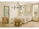 Stylized bedroom featuring neutral tones, an accent chandelier, and modern furniture at 9032 Selborne Ln, Chattahoochee Hills, GA 30268