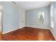 Bright bedroom with hardwood floors, blue walls, and white trim and one window at 9032 Selborne Ln, Chattahoochee Hills, GA 30268