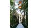 Bridge with lanterns in a wooded area leading to a house in the distance at 9032 Selborne Ln, Chattahoochee Hills, GA 30268