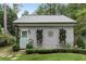 Quaint backyard cottage featuring gray siding, a minimalist landscape design, and a light teal front door at 9032 Selborne Ln, Chattahoochee Hills, GA 30268