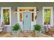 Charming front entrance with a light blue door, decorative lanterns, and stone walkway at 9032 Selborne Ln, Chattahoochee Hills, GA 30268