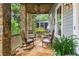 Covered porch with rocking chairs, stone pillars, and ceiling fan at 9032 Selborne Ln, Chattahoochee Hills, GA 30268