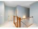Upstairs hallway with wainscotting, wood railing and white carpet at 9032 Selborne Ln, Chattahoochee Hills, GA 30268