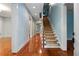 Light-filled hallway with hardwood floors and staircase leading to the upper level at 9032 Selborne Ln, Chattahoochee Hills, GA 30268