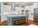 Modern kitchen with white cabinets, center island, and stainless steel appliances at 9032 Selborne Ln, Chattahoochee Hills, GA 30268