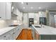A spacious kitchen boasts white cabinets, stainless steel appliances, and a marble island countertop at 9032 Selborne Ln, Chattahoochee Hills, GA 30268