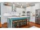 White kitchen with light blue island, stainless steel appliances, and ample counter space at 9032 Selborne Ln, Chattahoochee Hills, GA 30268