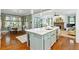 Open floor plan with a kitchen island and a living room with a fireplace at 9032 Selborne Ln, Chattahoochee Hills, GA 30268