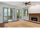 Inviting living room with stone fireplace, French doors opening onto a screened-in porch at 9032 Selborne Ln, Chattahoochee Hills, GA 30268
