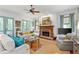 Cozy living room features a stone fireplace, ceiling fan, and French doors to the outside at 9032 Selborne Ln, Chattahoochee Hills, GA 30268