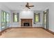Spacious living area with a stone fireplace, built-in shelving, and French doors to the porch at 9032 Selborne Ln, Chattahoochee Hills, GA 30268