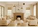 Bright living room featuring elegant fireplace, matching sofas, armchairs, and neutral decor at 9032 Selborne Ln, Chattahoochee Hills, GA 30268