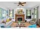 Cozy living room features a stone fireplace, ceiling fan, and French doors to the outside at 9032 Selborne Ln, Chattahoochee Hills, GA 30268