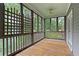 Covered porch boasting a wood floor, a ceiling fan, and views of the surrounding wooded backyard at 9032 Selborne Ln, Chattahoochee Hills, GA 30268