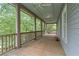 Expansive covered porch with wooden floors, railings, and ceiling fan offers relaxing outdoor living space at 9032 Selborne Ln, Chattahoochee Hills, GA 30268