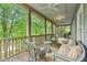 Relaxing screened porch with wicker furniture and lush green views at 9032 Selborne Ln, Chattahoochee Hills, GA 30268