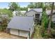 Rear view of the home showing the garage, screened porch and outdoor seating area at 9032 Selborne Ln, Chattahoochee Hills, GA 30268