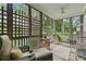 Relaxing screened porch with wicker furniture and leafy views at 9032 Selborne Ln, Chattahoochee Hills, GA 30268